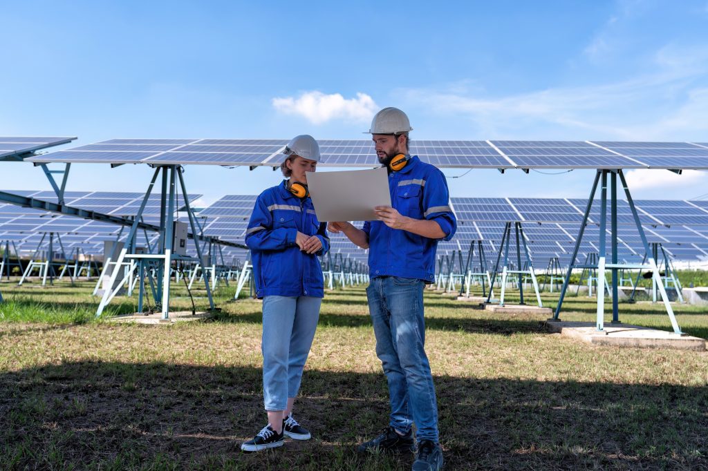 Maintenance engineer at solar farm looking drawing discuss on expansion upgrade electricity plant