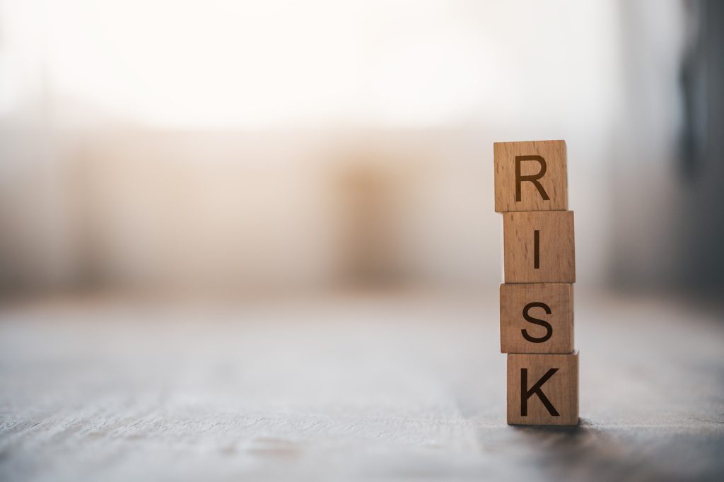 wooden block with the word "RISK". Concept risk management.